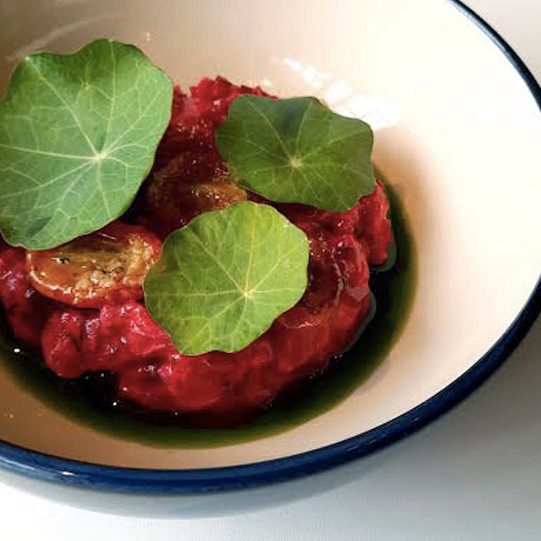 Tartare de atún fresco, aceite de achiote y chile guaque, remolacha encurtida con jengibre, cilantro y aceite de hierbas. Arriba para acompañar, unas hojas de mastuerzo y tomates cherry aliñados con aceite.